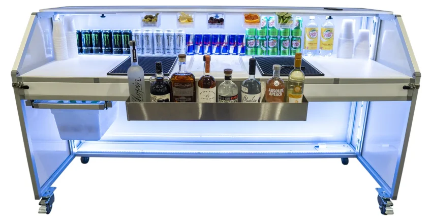 Bartender workspace view of the LED lighted Signature 77 portable bar fully stocked with a stainless steel speed rail, center ice bin, prep mats, garnish rack, and slide-out storage.