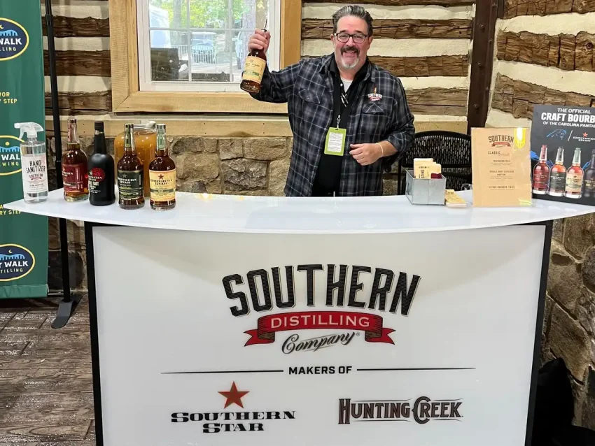Fusion 48 Mostrador portátil para exposiciones con gráficos personalizados con la marca para catas de licores y eventos. Portable bar counter with Southern Distilling Company branding at bourbon tasting event